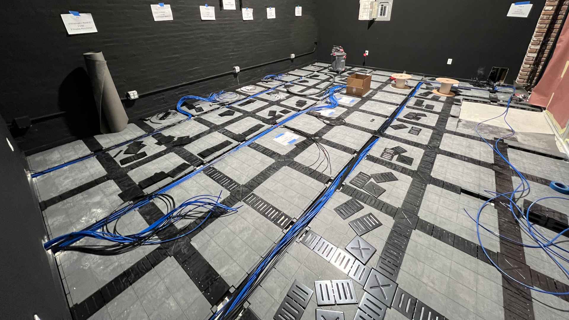 Picture of an in-progress install of false flooring for under-floor cable runs